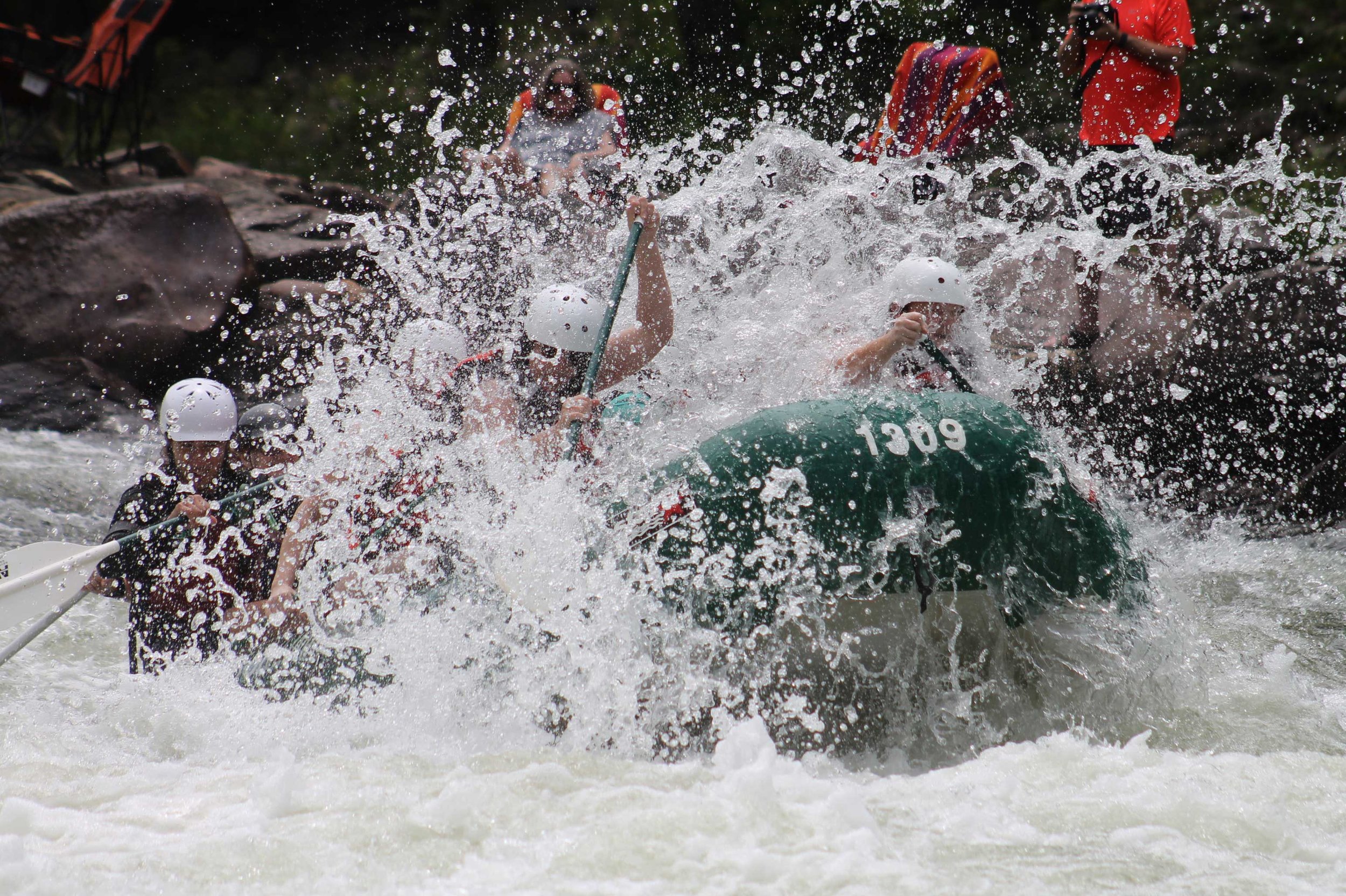 A team navigating whitewater rapids together